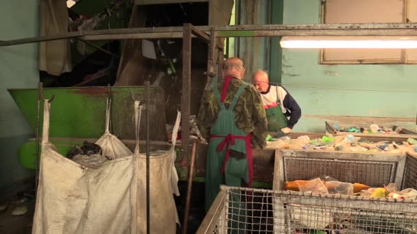 OLOMOUC, CZECH REPUBLIC, APRIL 25, 2018: Line for industrial sorting of different types of plastics waste. Poor and people job. They are sorting on blue, green and transparent PET bottles, recycling — Stock Video