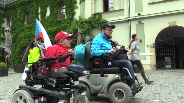 OLOMOUC, RÉPUBLIQUE TCHÈQUE, 9 MAI 2018 : Deux hommes invalides sur un fauteuil roulant électrique moderne, la situation authentique de la conversation et la réalité de l'homme dur dans la vie de l'homme — Video