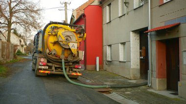 Olomouc, Çek Cumhuriyeti, 30 Aralık 2019: Basınç altında boru tankı vakum hortumuna boşaltma lağım çukuru. Sular kirlilik, atık atık su içerir, insanlar köye ev sahipliği yapar
