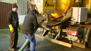 Olomouc, Çek Cumhuriyeti, 30 Aralık 2019: Septik lağım çukuru yüksek basınç altında boru tankı vakum hortumuna pompalanarak boşaltılıyor. Sular kirlilik içerir, atık su siyah, insanlar işçi