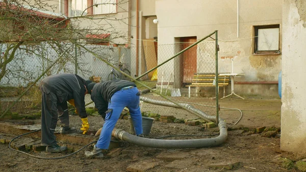 Olomouc, Çek Cumhuriyeti, 30 Aralık 2019: Septik lağım çukuru yüksek basınç altında boru tankı vakum hortumuna pompalanarak boşaltılıyor. Sular kirlilik içerir, atık su siyah, insanlar işçi