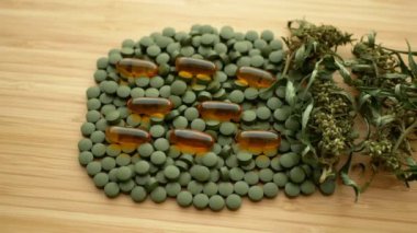 Cannabis tablets medical capsules seeds big bud dry with pistils or pills hemp and leaf cannabidiol CBD harvested dried of seeds quality for the production developed, relieves pain, antibacterial and soothing, seeds big bud with pistils, stigmas.