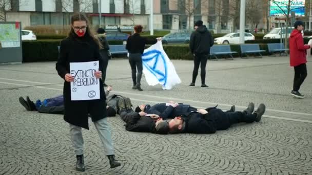 OLOMOUC, CZECH REPUBLIC, JANUARY 10, 2019: Extinction rebellion activist Anna Martinkova banner symbol circle hourglass warning, people lie on ground square showing death, demonstration — 图库视频影像