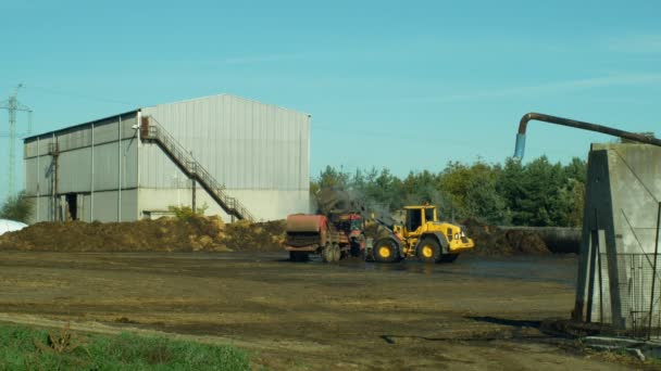 OLOMOUC, REPUBBLICA CECA, 10 SETTEMBRE 2019: Rimorchio del trattore che diffonde fertilizzante agricoltura dei campi di liquame, discarica letame di letame di grande fossa letame letame sterco, carico bulldozer caricatore Volvo — Video Stock