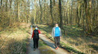 OLOMOUC, CZECH REPUBLIC, Mart 28, 2020: Face mask coronavirus risk covid-19 yürüyüş Orman doğası erkek erkeğe romantik yol taze hava sağlığı, eşarp şalı salgını Çek karantina sınırlaması 
