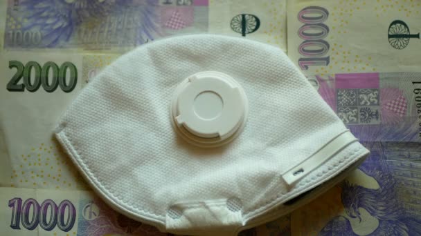 BRNO, TSJECHIË, 13 maart 2020: FFP2 masker gezicht coronavirus covid-19 en Tsjechische geld valuta bankbiljetten, ffp mensen preventie infectie veiligheid uitbraak. het dragen van ademhalingskleding — Stockvideo