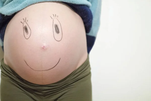 Lustige Gesichter auf dem Bauch — Stockfoto