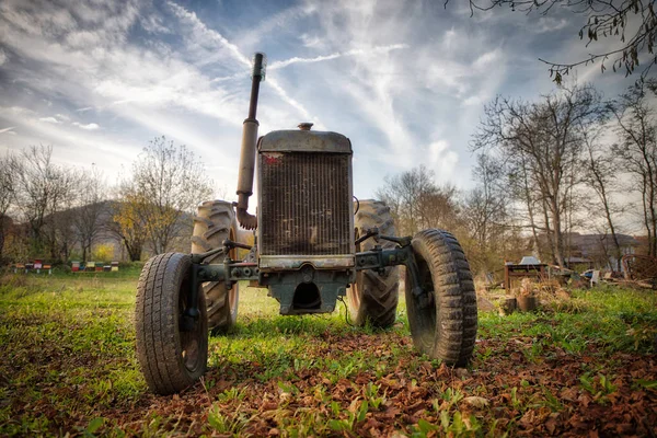 Viejo tractor oxidado en un campo en un día soleado — Foto de Stock