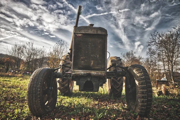 Stary zardzewiały traktor na polu w słoneczny dzień — Zdjęcie stockowe