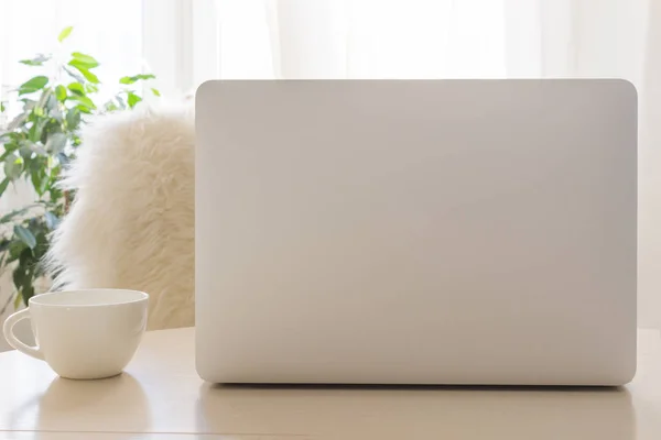 Cozy workplace with modern Laptop and white cup. Mockup