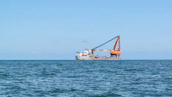 Heavy lift ship with crane sailing on North Sea leaving port of — Stock Photo, Image