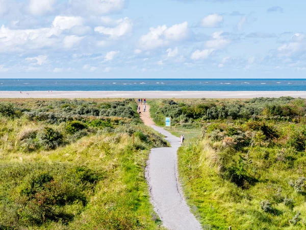 Personas caminando por sendero a la playa del Mar del Norte de Schiermonnikoog —  Fotos de Stock