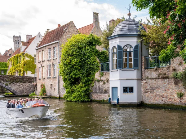 Personas en barco en el canal Groenerei en el casco antiguo histórico de Brujas, Bélgica — Foto de Stock