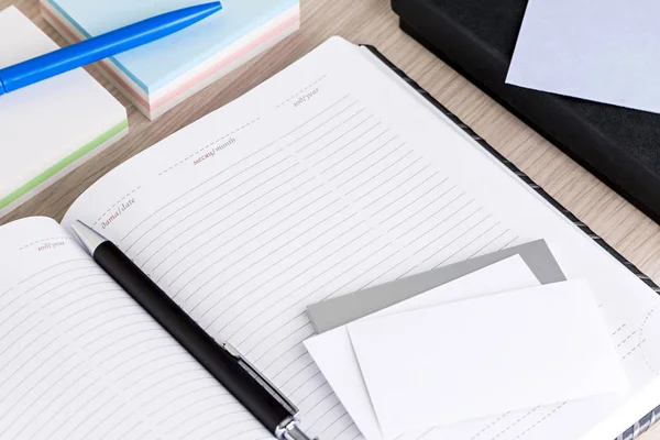 Bloc de notas en blanco abierto y pluma en un escritorio de un hombre de negocios — Foto de Stock