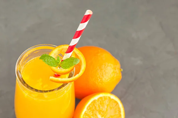 Primer plano de un vaso de jugo de naranja con frutas de naranjas —  Fotos de Stock