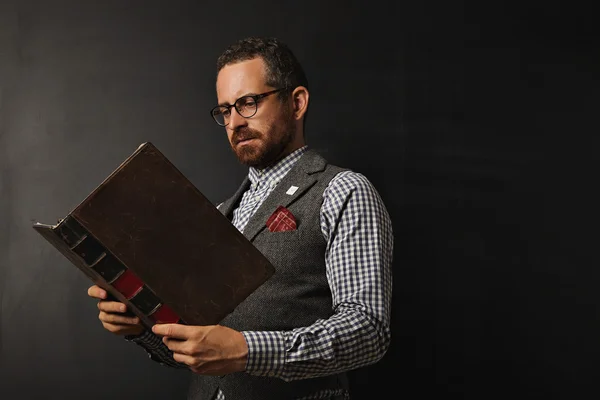 Serious fashionable male teacher reading