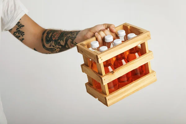 Hombre sosteniendo una caja de refrescos de naranja — Foto de Stock