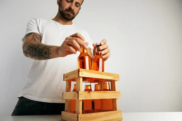 Man putting bottles into crate — Stock Photo, Image