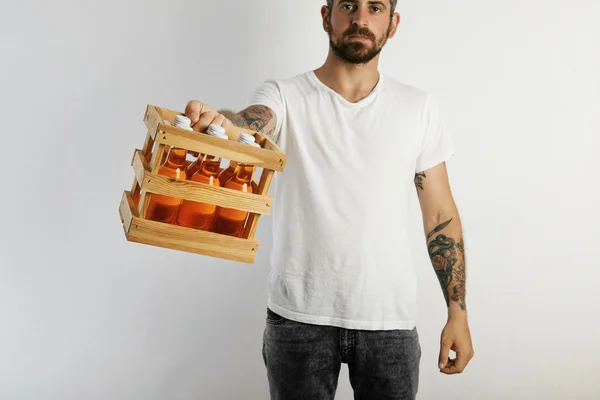 Homem oferecendo caixa de bebidas laranja — Fotografia de Stock