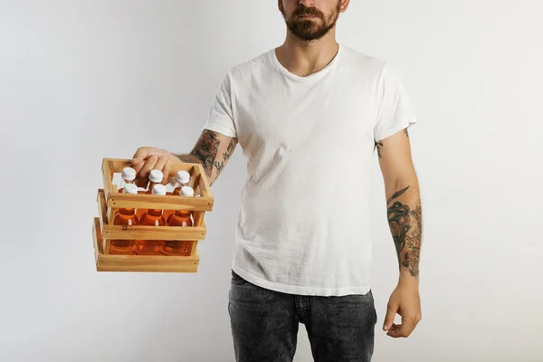 Hombre sosteniendo paquete de bebidas naranjas — Foto de Stock