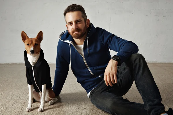 Man and dog in dark hoodies — Stockfoto