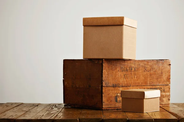 Blank corrugated cardboard boxes with vintage wooden box — Stock Photo, Image