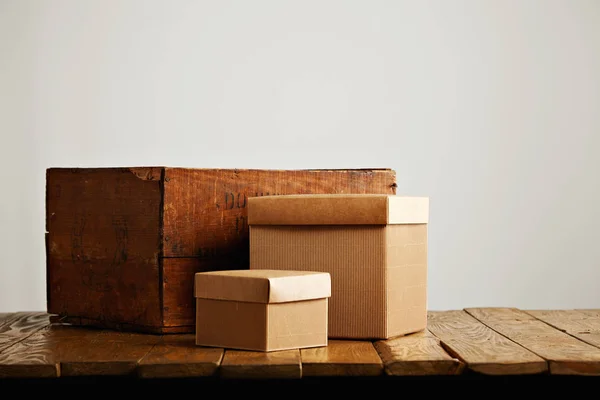 Cajas de cartón corrugado en blanco con caja de madera vintage — Foto de Stock