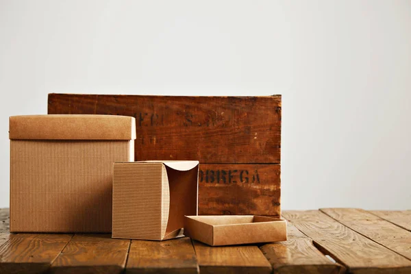 Κενό κυματοειδές χαρτόνι κουτιά, με vintage ξύλινο κουτί — Φωτογραφία Αρχείου