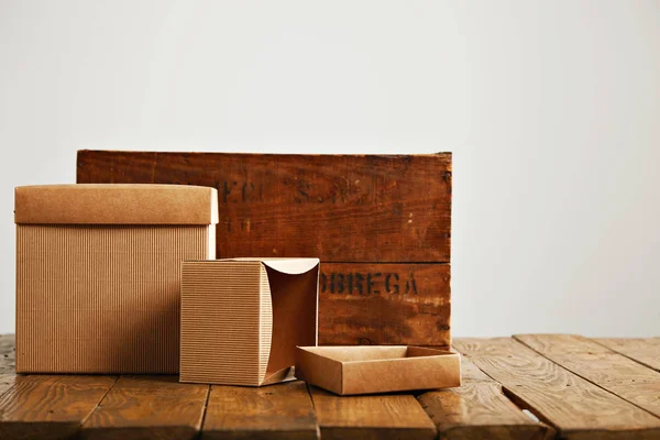 Blank corrugated cardboard boxes with vintage wooden box — Stock Photo, Image