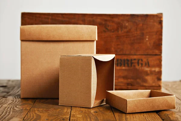 Caixas de papelão ondulado em branco com caixa de madeira vintage — Fotografia de Stock
