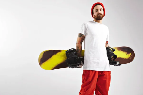 Joven con una tabla de snowboard en el estudio — Foto de Stock