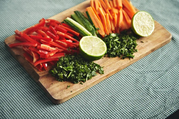 Frisches Gemüse auf einem Holzbrett schneiden — Stockfoto