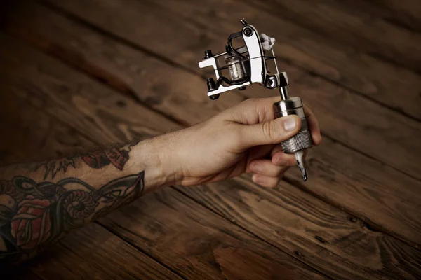 Fechar a mão de um homem com arma de tatuagem — Fotografia de Stock