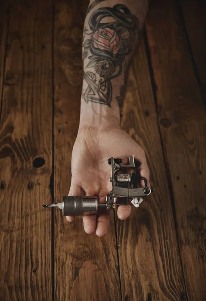 Close up of a mans hand with  tattoo gun