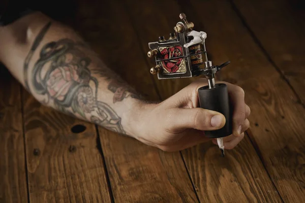 Primer plano de una mano de hombre con pistola de tatuaje — Foto de Stock