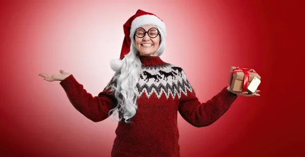 Femme en pull de Noël et chapeau de Père Noël avec des cadeaux — Photo