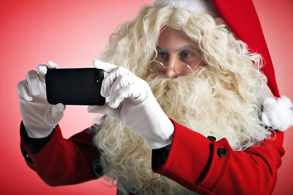 Weihnachtsmann mit Gadgets in der Hand — Stockfoto