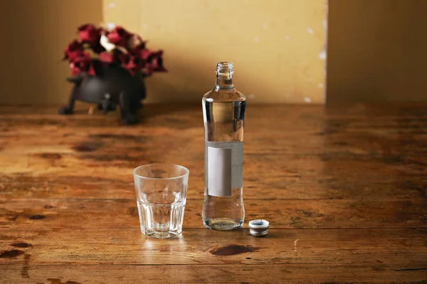 Bottle of water and glass in rustic kitchen