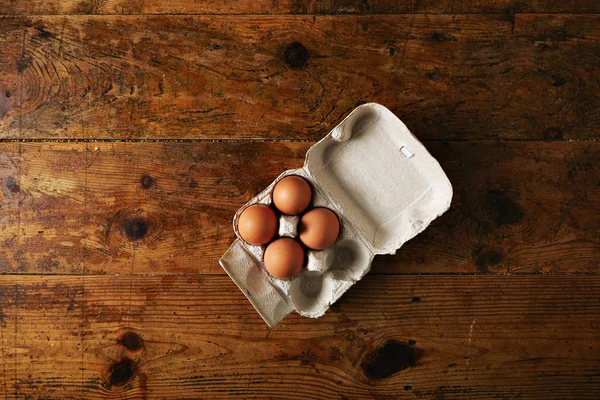 Caja de huevos sobre una mesa de madera —  Fotos de Stock