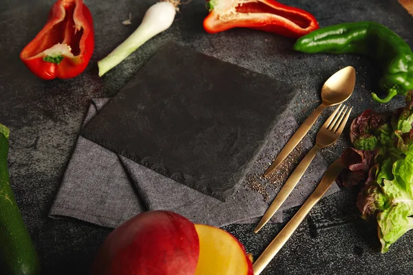 Овощи вокруг черной доски с сыром — стоковое фото