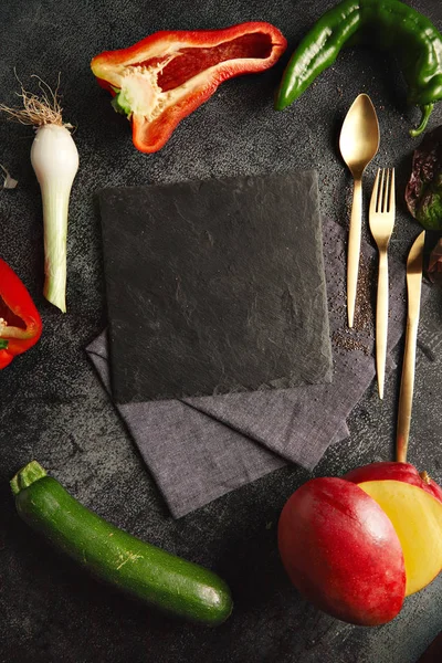 Verduras alrededor de una pizarra de queso negro —  Fotos de Stock