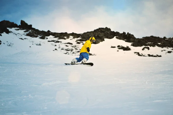 Snowboarding ao pôr do sol nas montanhas — Fotografia de Stock