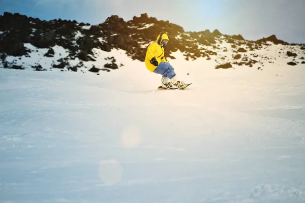 Snowboarding ao pôr do sol nas montanhas — Fotografia de Stock