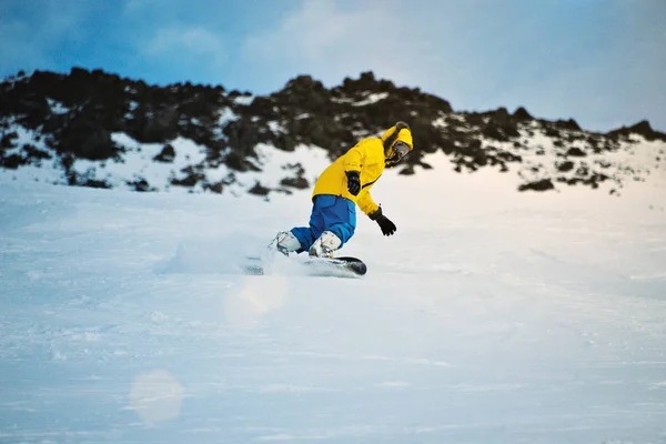 Snowboarding at sunset in mountains — Stock Photo, Image