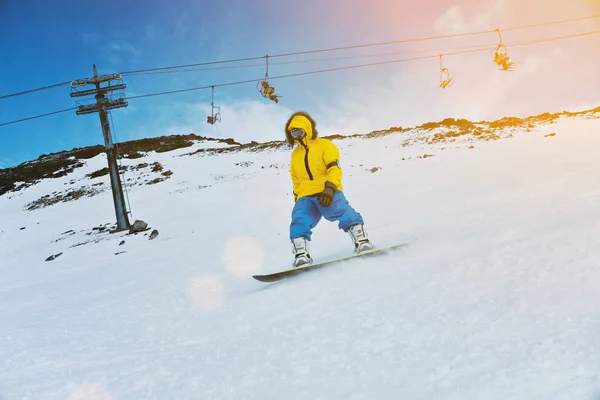 Snowboarding ao pôr do sol nas montanhas — Fotografia de Stock