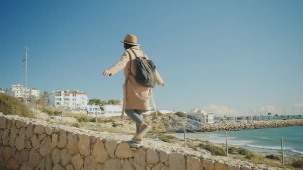 Attraente ragazza passeggiate vicino alla linea di costa nella piccola città mediterranea — Video Stock