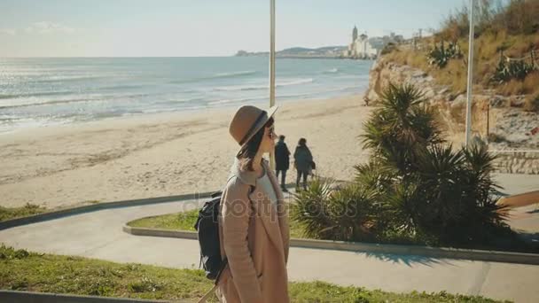 Attraktiv tjej går nära strandlinjen i Medelhavet småstad — Stockvideo