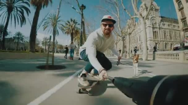 Adam köpeği takip onun longboard rides — Stok video