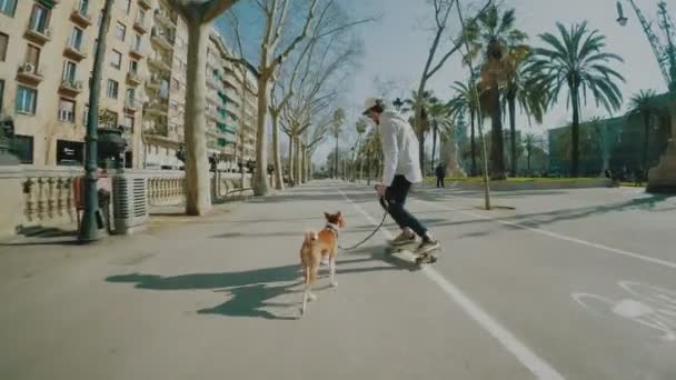Man rides his longboard followed by his dog — Stock Footage Man rides his longboard followed by his dog Stock Footage
