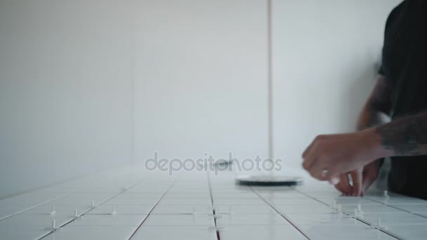 Tätowierter Mann klebt Keramikfliesen auf Küchentischgarnitur — Stockvideo